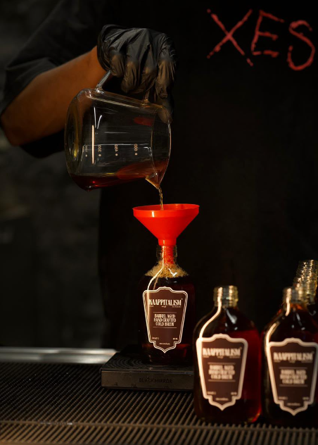 Barrel-aged cold brew hand-poured into a bottle